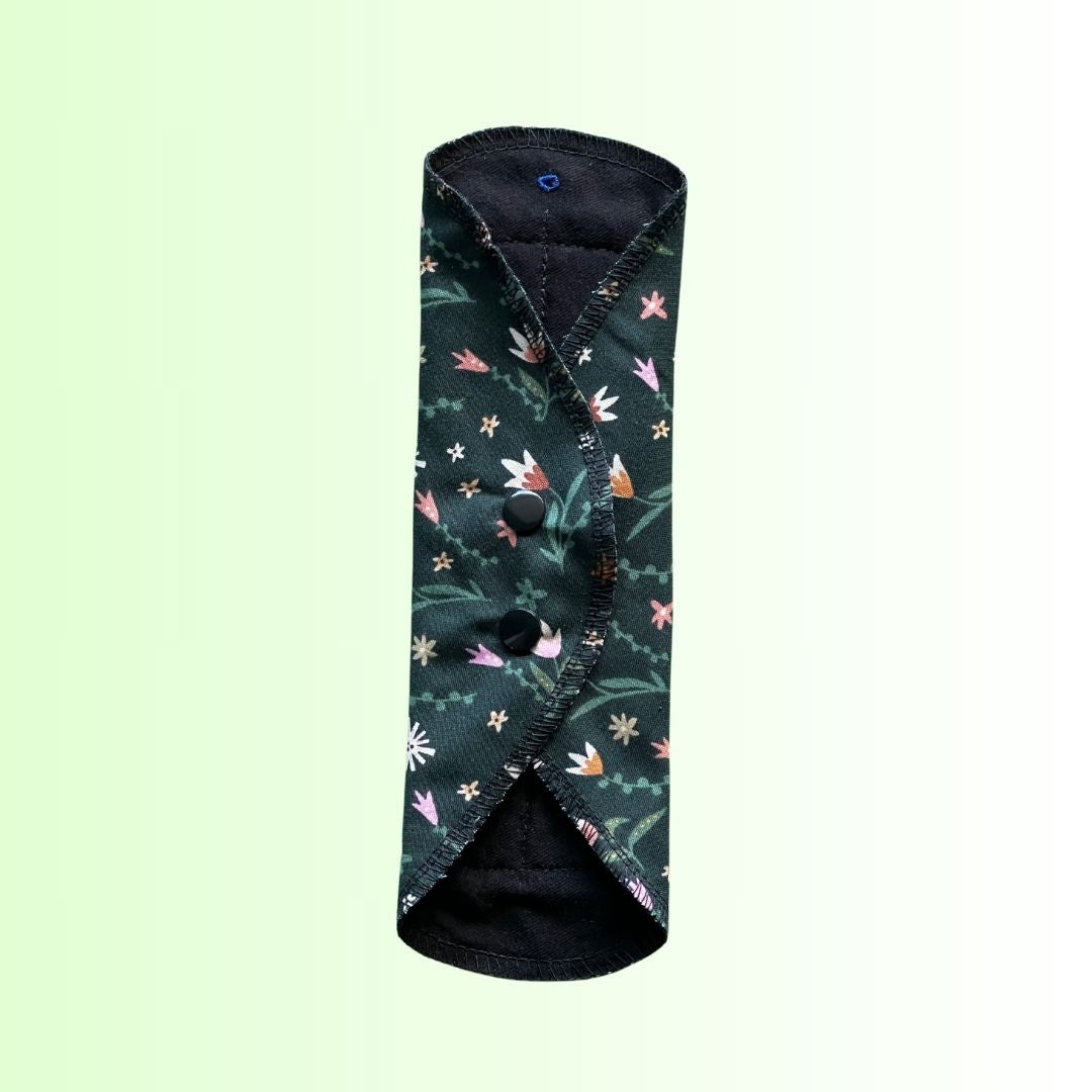 Reusable day pad in floral green print folded and snapped closed for storage or travel