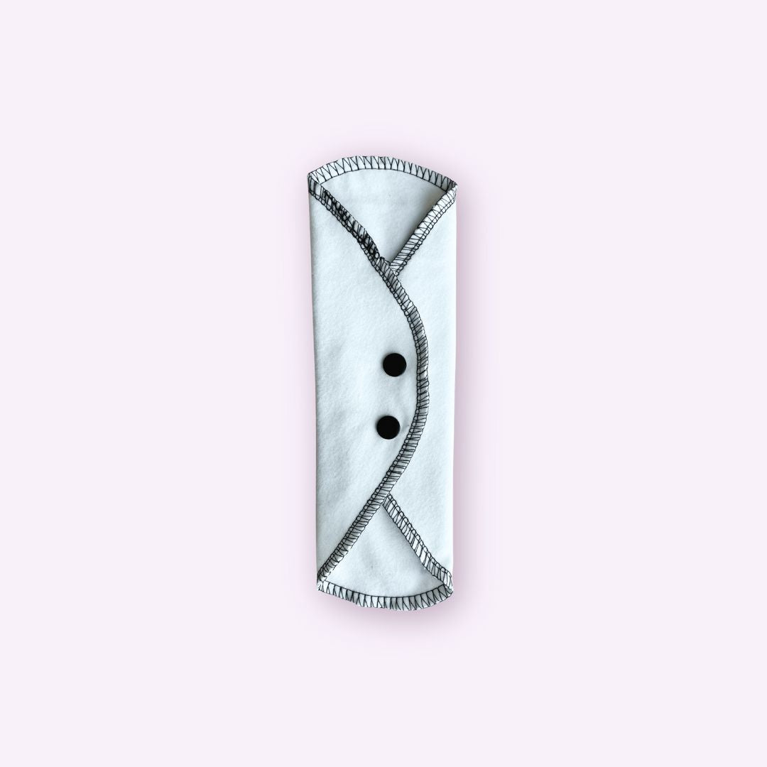 Teen cloth pad folded lengthwise with black snap closures – compact and easy to store