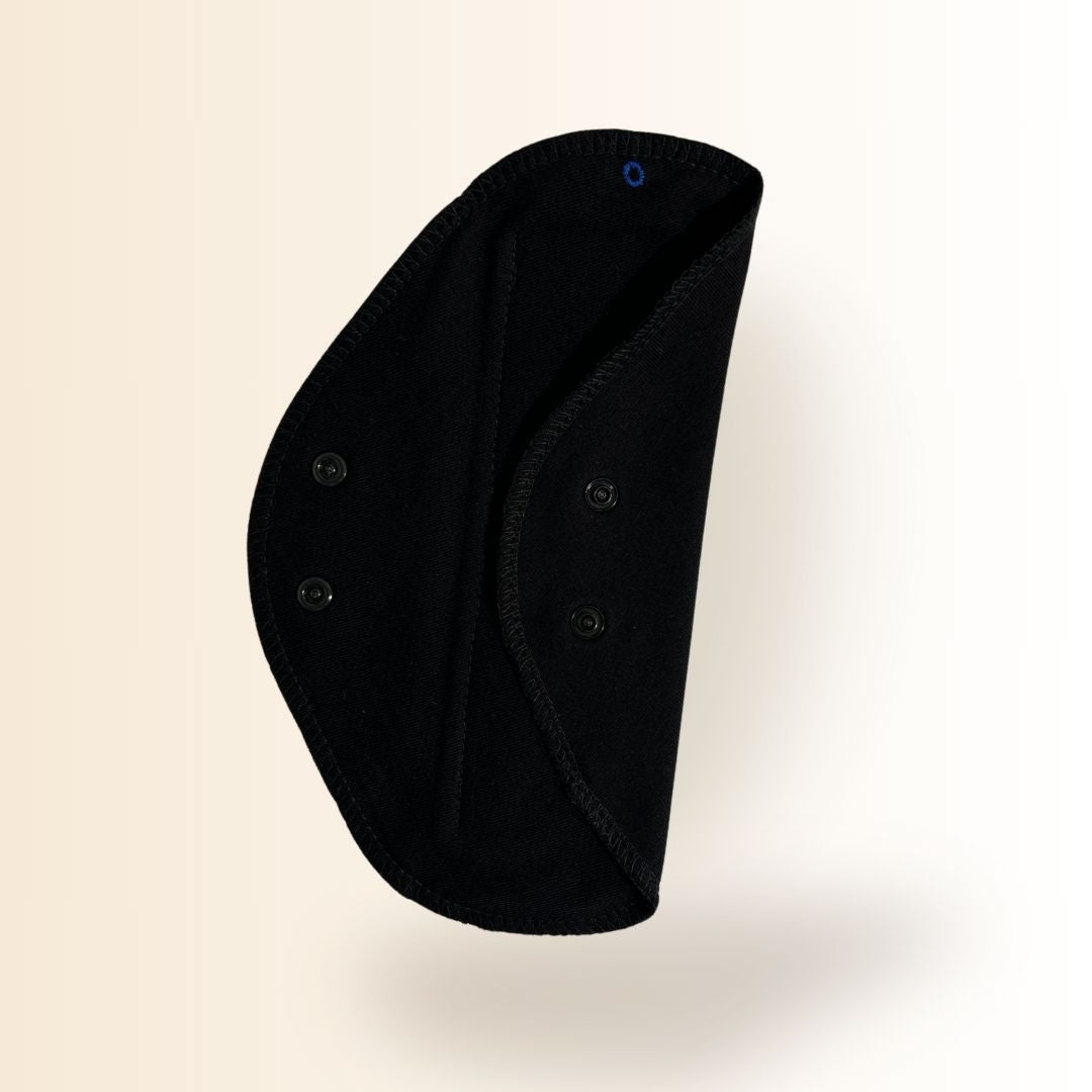 Black reusable day pad partially folded to show snap buttons and absorbent cotton side.