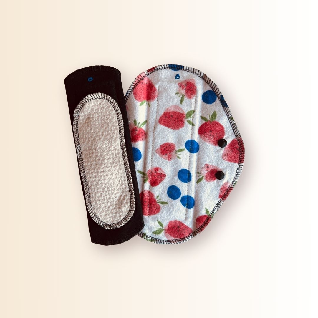 Hume’s reusable day pad with strawberry print next to the absorbent organic cotton core side for light to heavy flow.