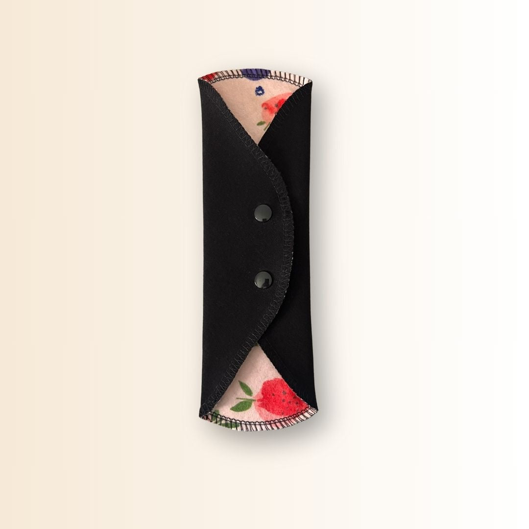 Reusable day pad with strawberry print – shown open with two wings folded.