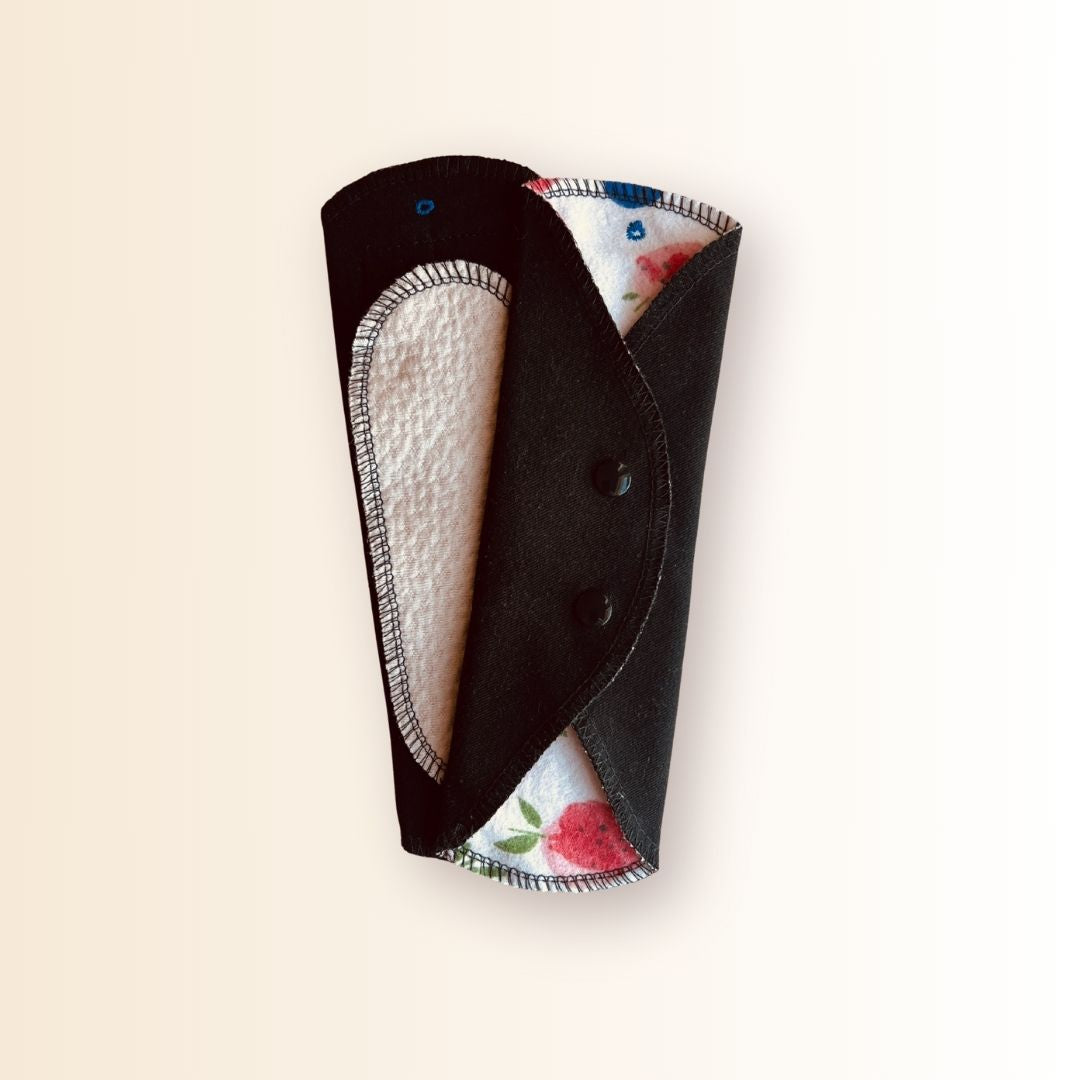 Strawberry print cloth day pad snapped shut for storage or transport.