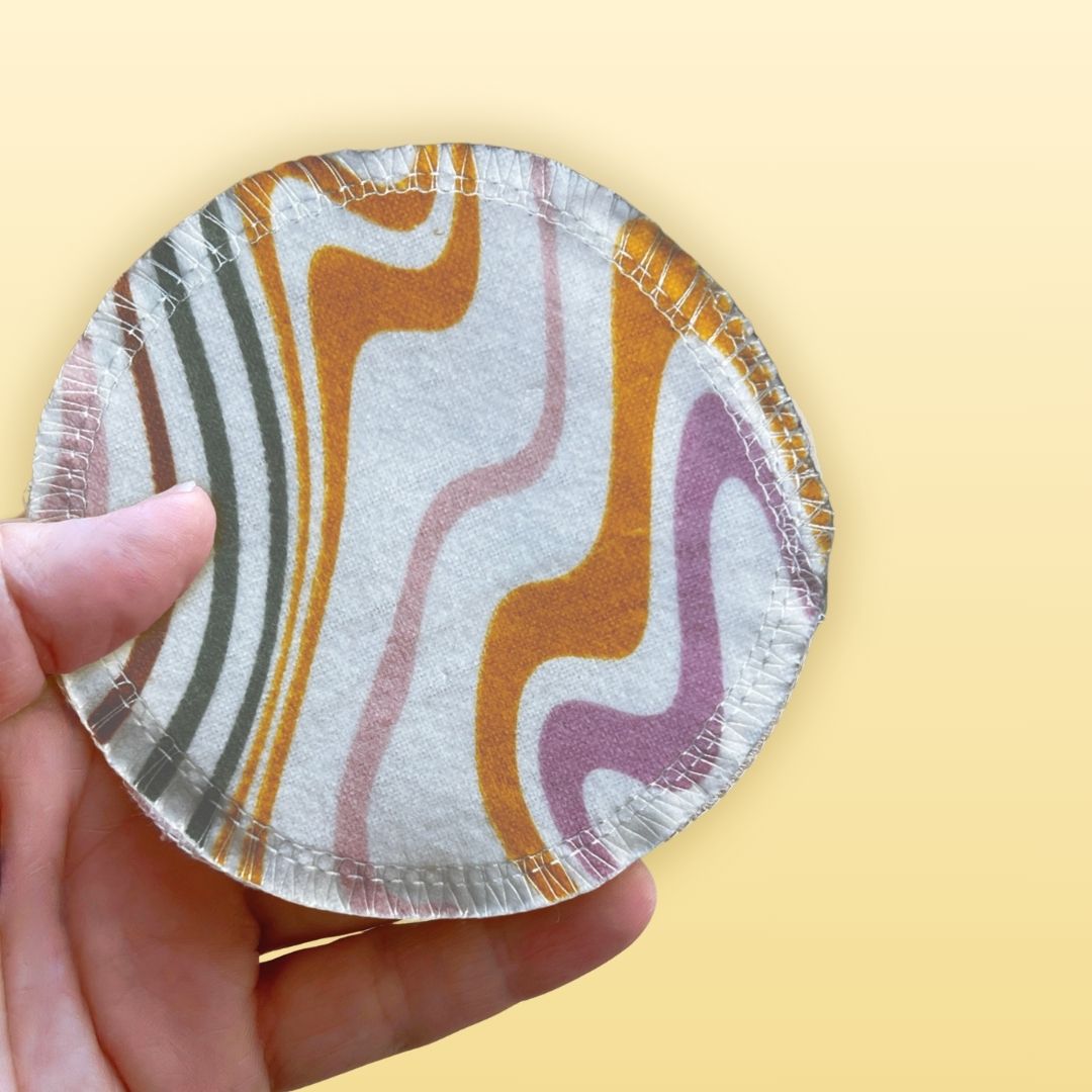 Reusable cotton face pad held in hand to show size and stitching detail