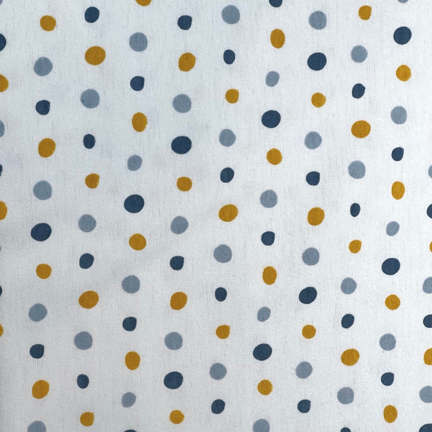 Cotton flannel fabric used for Hume’s Interlabial Pads, featuring a white background with mustard yellow, grey, and navy blue polka dots