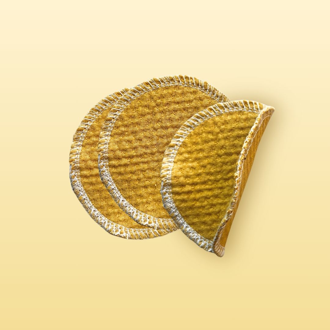 Golden sand organic cotton face pads with one flipped to show texture and thickness