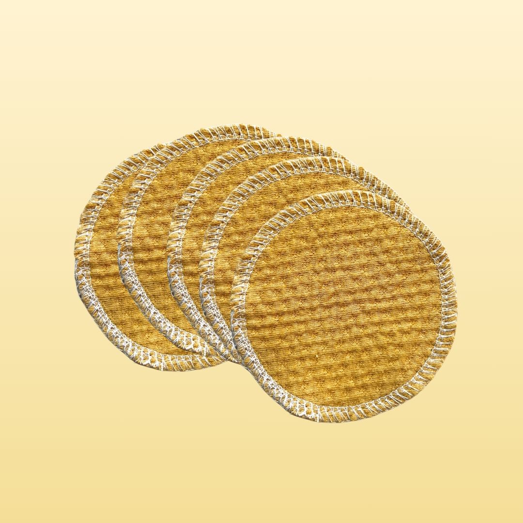 Stack of 100% organic cotton face pads in golden sand color, round reusable design