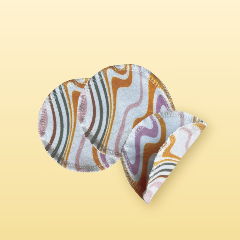 Reusable round cotton flannel face pads with orange, purple, and gray swirl print