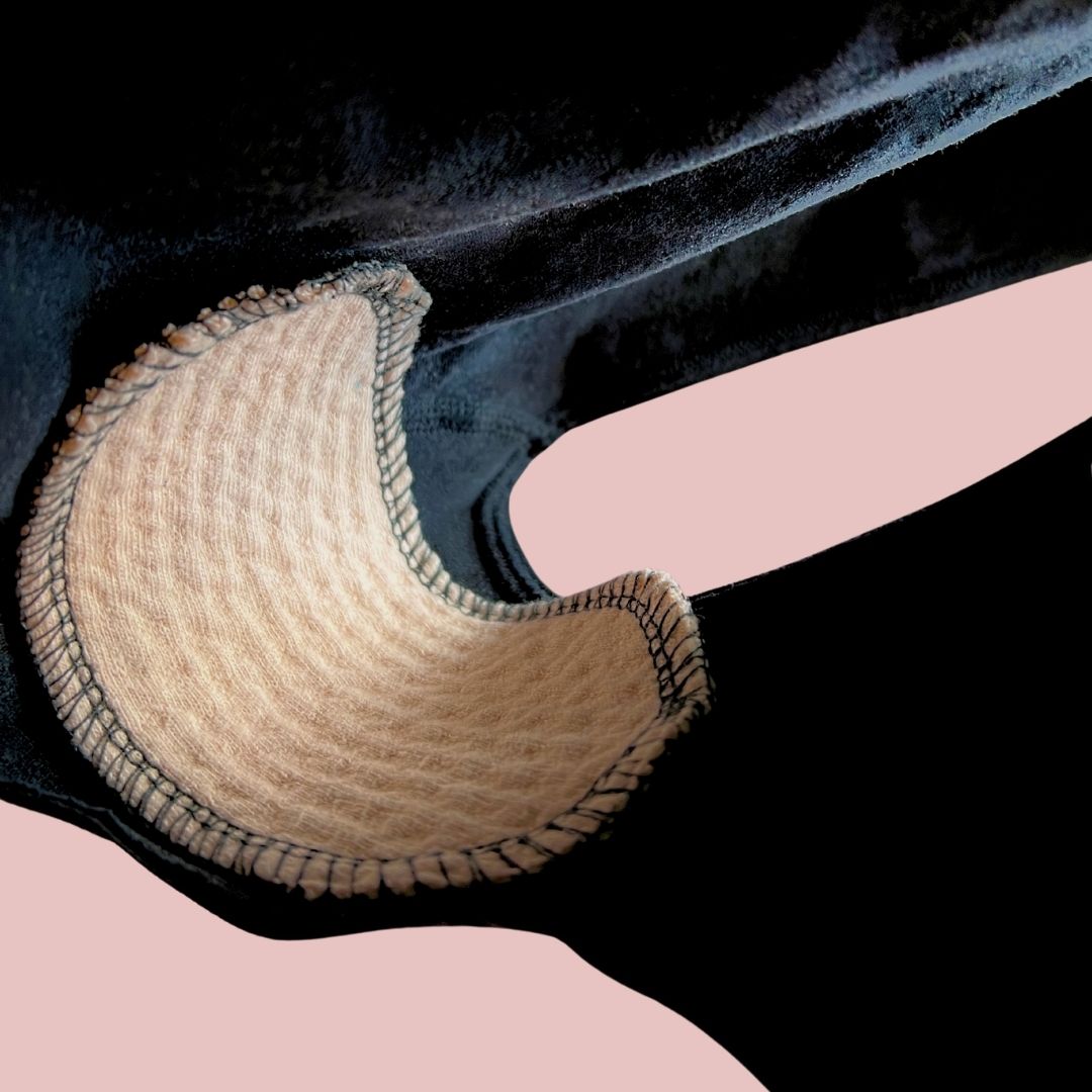 Organic cotton interlabial pad placed inside black underwear, showing flexible and discreet fit.
