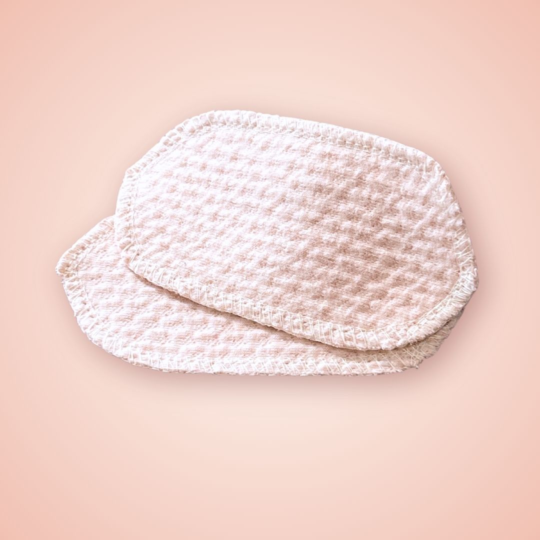 Top view of two soft organic cotton interlabial pads in light pink color, perfect for spotting or daily wear.