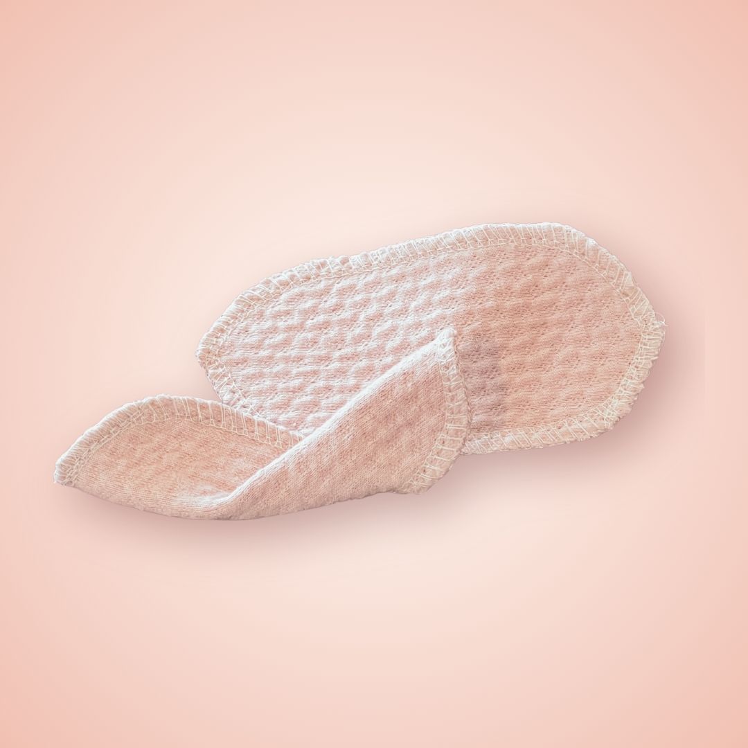 Reusable interlabial pads in organic cotton, side view showing the natural weave texture.
