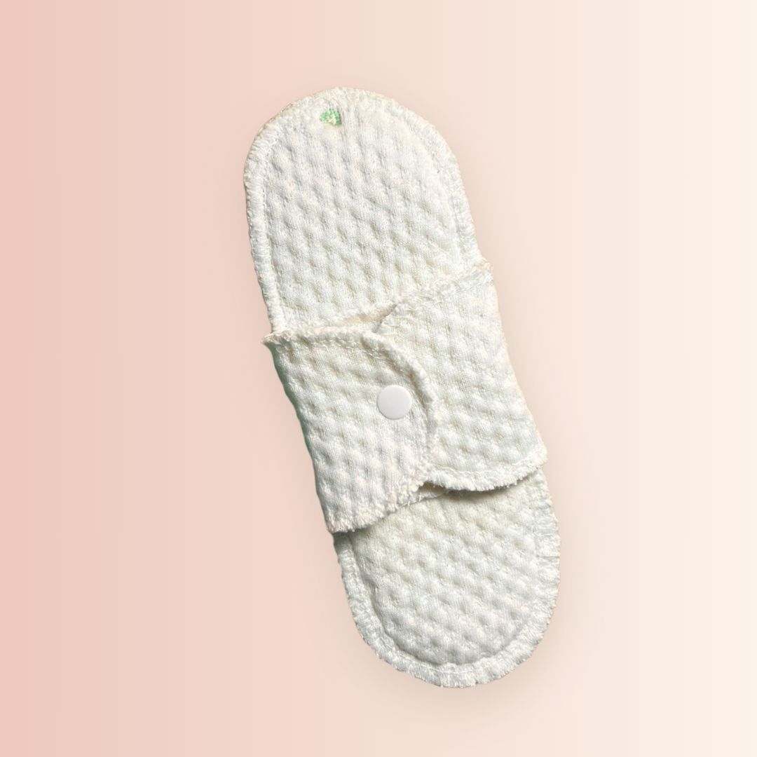 Close-up of organic cotton pad with color-coded stitching for flow level