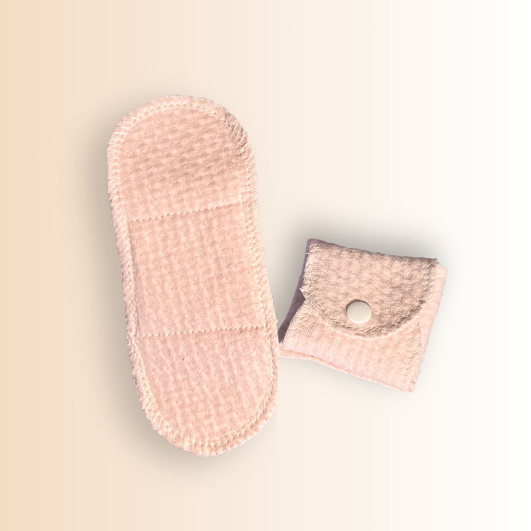 Reusable organic cotton menstrual pad shown fully open and folded with snap closure