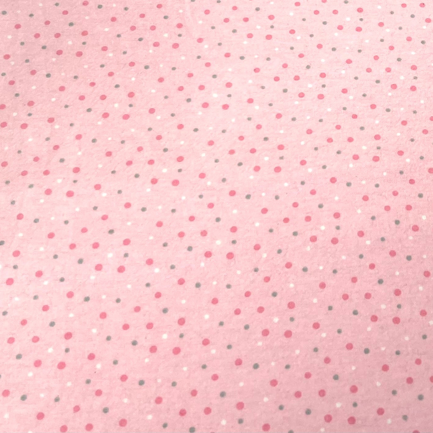 Close-up of pink polka dot fabric used in Hume’s reusable pads – soft cotton material with tiny white, gray, and dark pink dots.