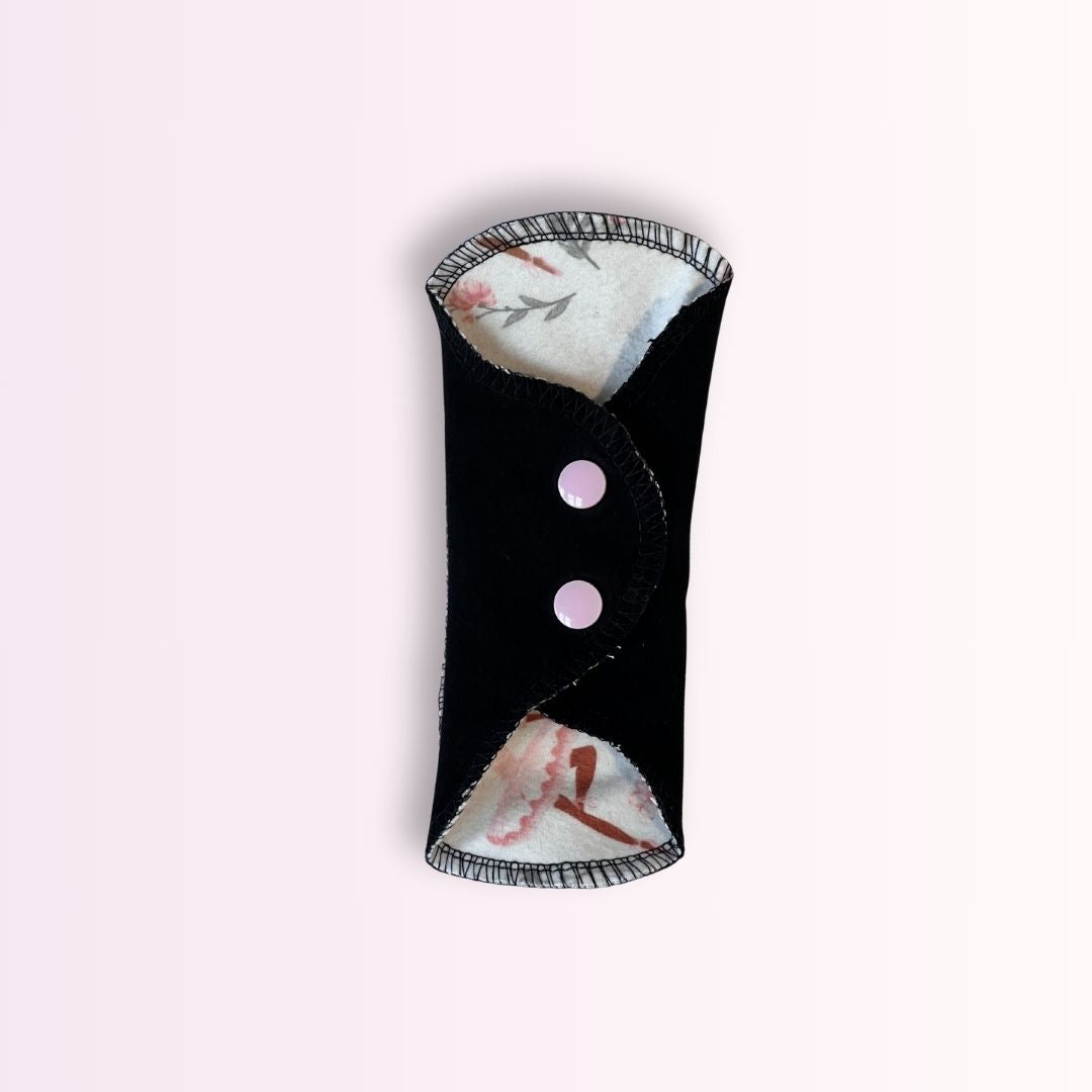 Folded ballerina teen period pad with pink snap closure. Compact and portable reusable pad for on-the-go teens.