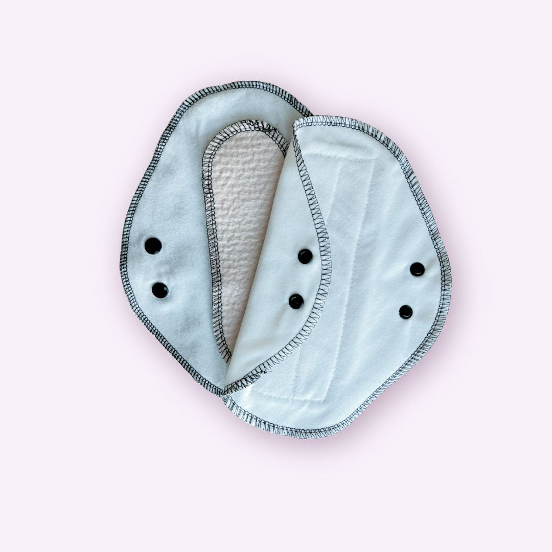 Two reusable teen pads in white flannel – one showing absorbent core, the other flat with black snaps