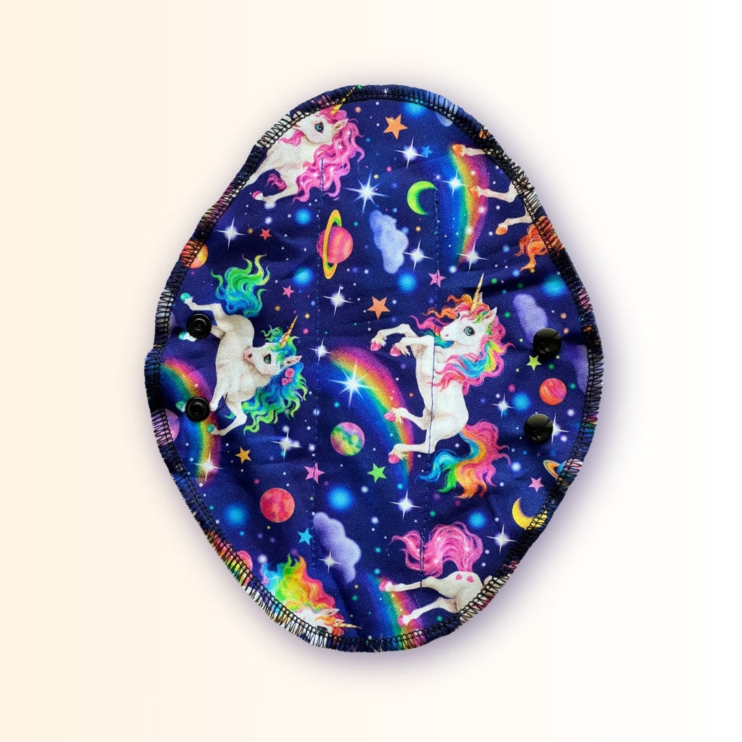 Unicorn reusable period pad with rainbow galaxy print, black snaps, and washable cloth design from Hume’s Period Care.