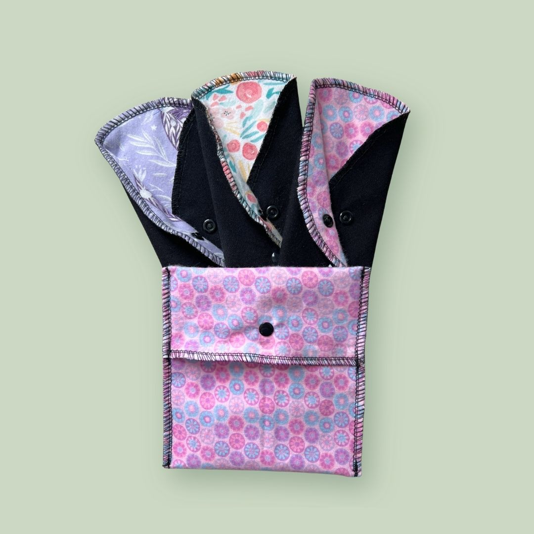 Back-to-school reusable period kit with three cloth pads and a pink travel wrapper.
