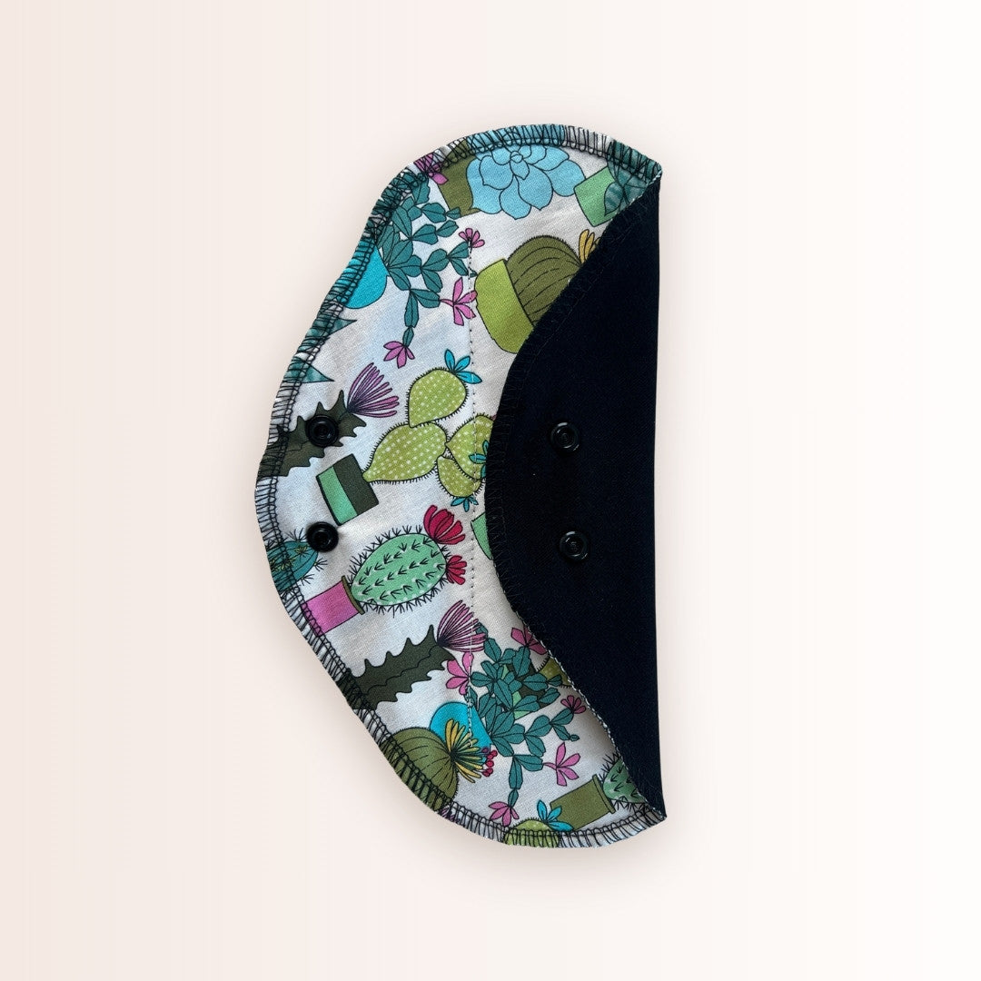 Cactus print reusable cloth pad with black absorbent cotton side.