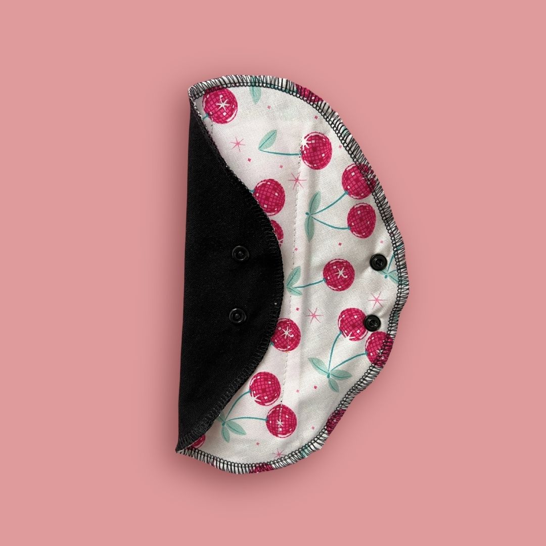 Reusable cloth pad opened to show shape, wings, and snap closure