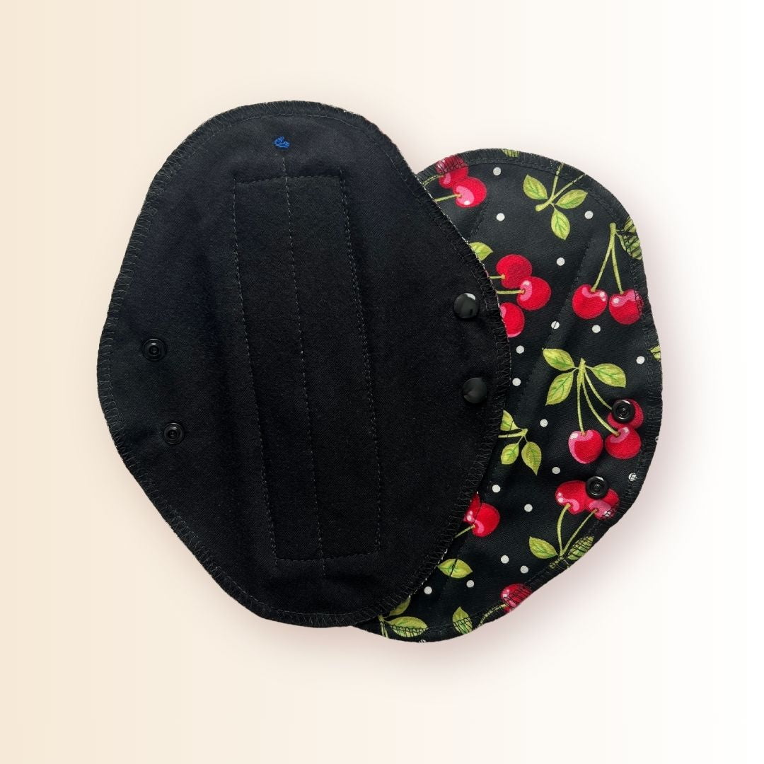 Cherry reusable day pad showing front and absorbent side