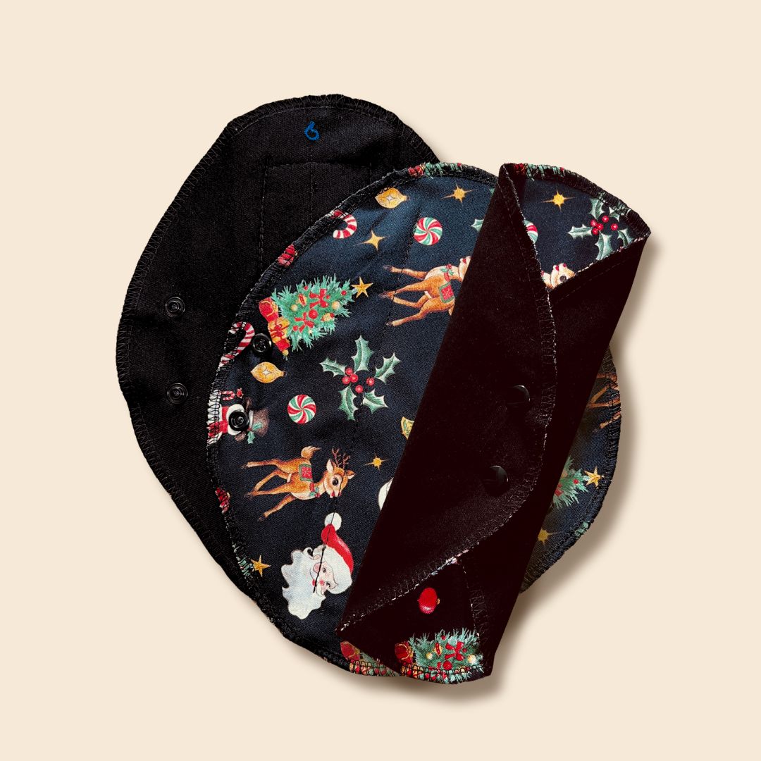 “Reusable pad with Santa and reindeer print — snap-wing detail.