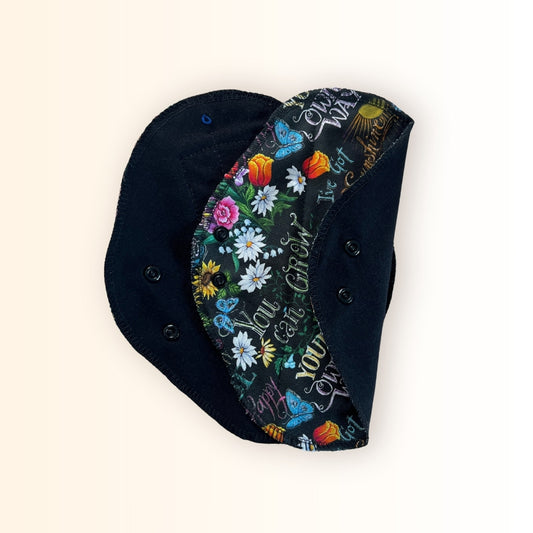 Reusable cloth pads in a sunshine floral print with black absorbent layer.
