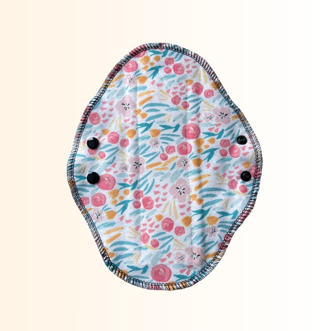 Full floral print side of a reusable cloth day pad with adjustable snap wings.