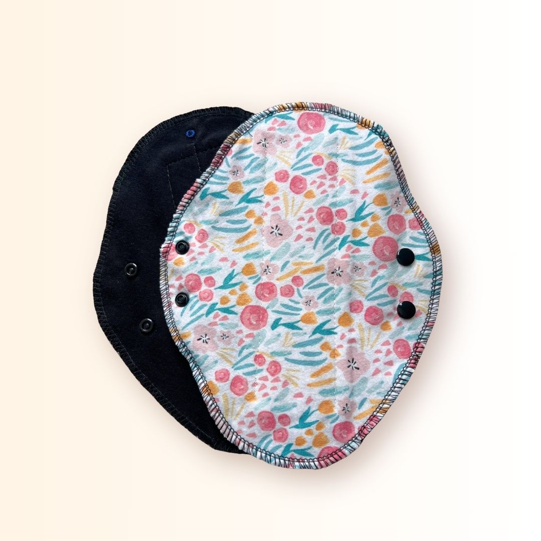 Full floral print side of a reusable cloth day pad with adjustable snap wings.
