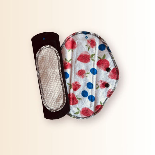 Hume’s reusable day pad with strawberry print next to the absorbent organic cotton core side for light to heavy flow.