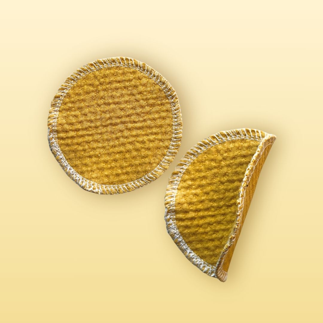 Round organic cotton face pads in golden sand, one flat and one folded to show detail