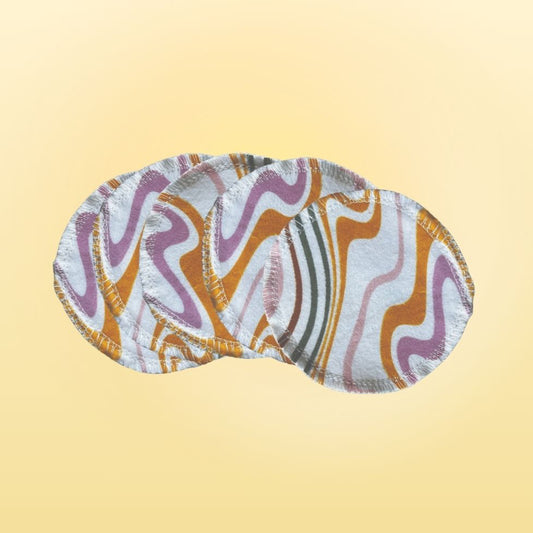 Top view of colorful round reusable cotton flannel face pads in a swirl pattern, set of four