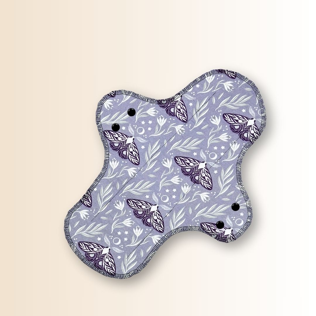  Front view of Hume’s reusable night pad in moth design, featuring flared shape and soft cotton top layer.