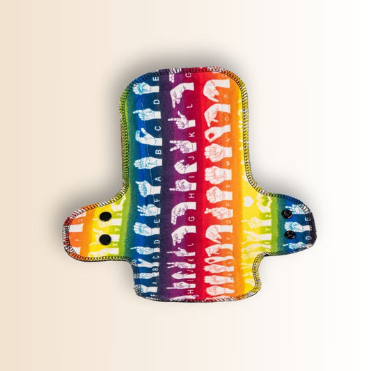 Rainbow-themed night menstrual pad with long flared shape and waterproof backing