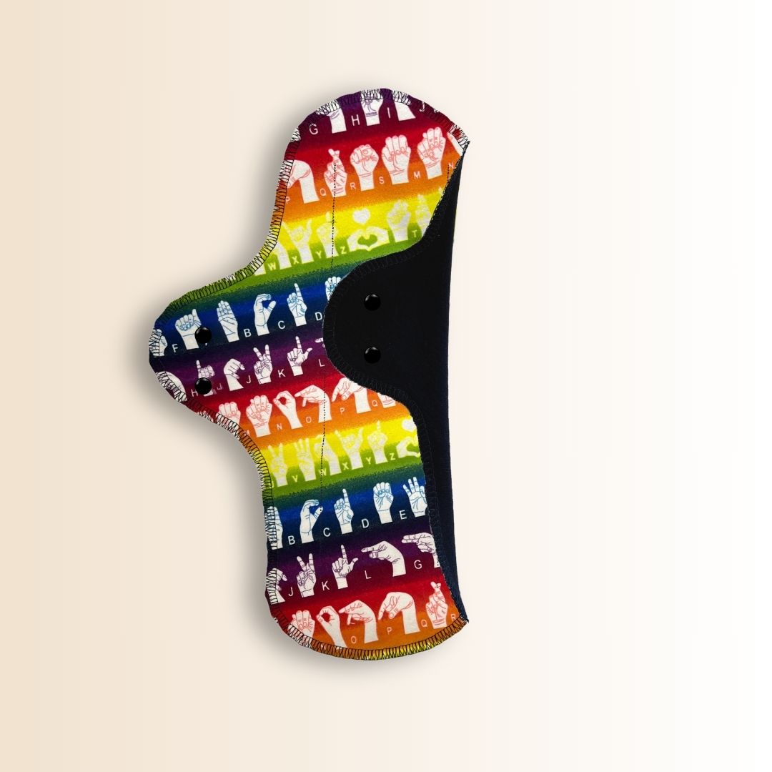 Folded view of reusable rainbow night pad showing secure snap and soft layers