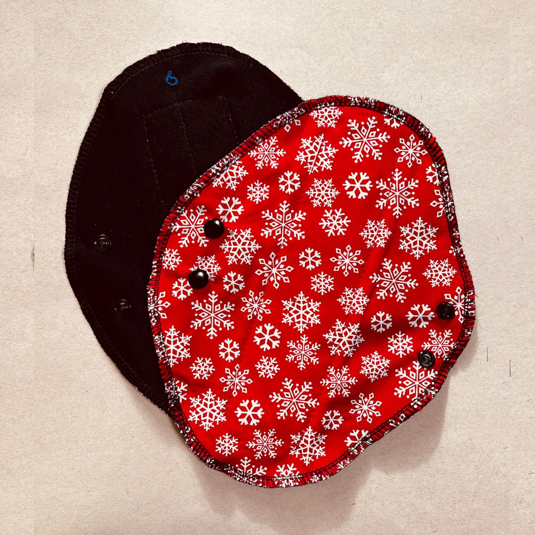 Black reusable menstrual pad with Christmas print — organic cotton core, holiday edition