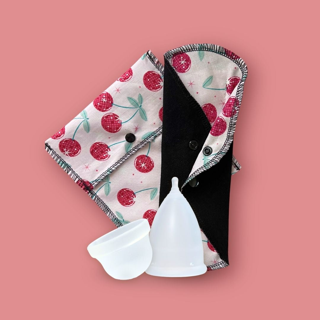 July reusable period care favorites with Hume’s menstrual cups, cherry print reusable cloth pad, and matching carry pouch
