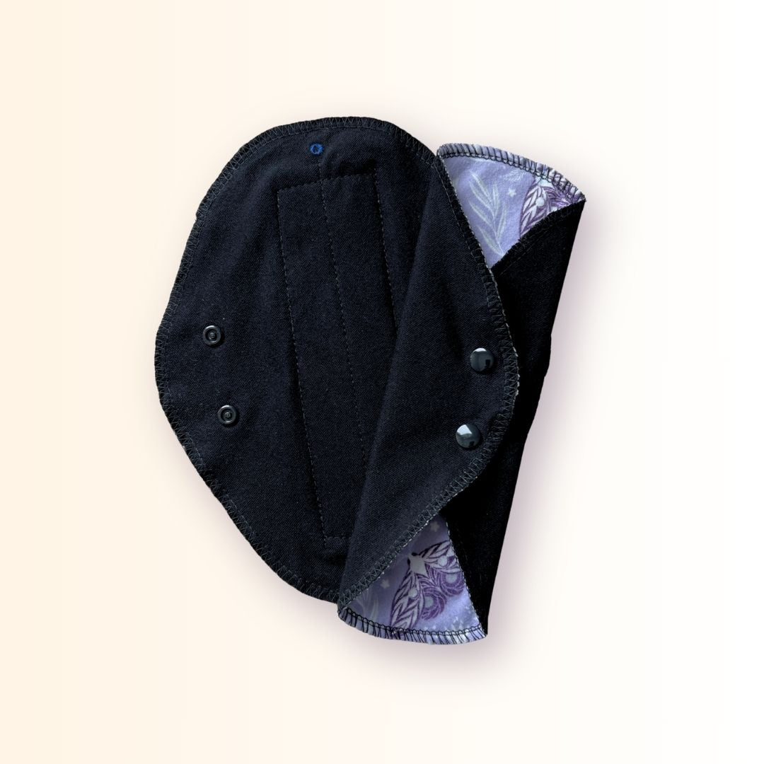 Lavender moth reusable cloth pad folded and snapped for compact storage in a bag or travel wrapper.