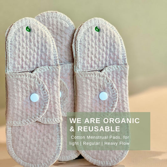 Set of organic reusable cotton menstrual pads for light, regular, and heavy flow with soft pink texture and white snaps