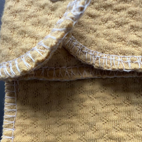 rganic sand color reusable day pad shown in close-up, featuring exposed organic cotton core, snap closure, and washable design for everyday period care