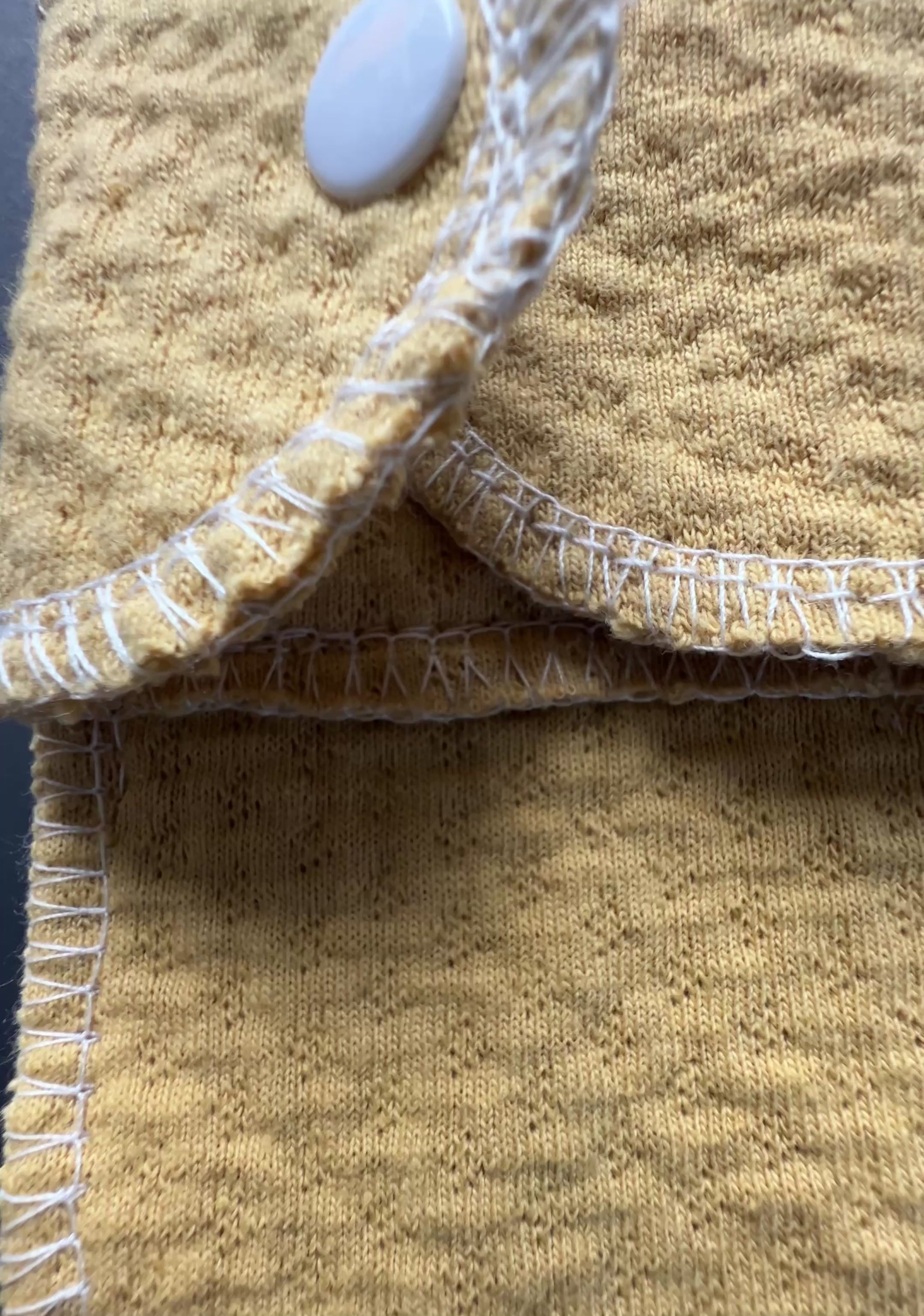 rganic sand color reusable day pad shown in close-up, featuring exposed organic cotton core, snap closure, and washable design for everyday period care