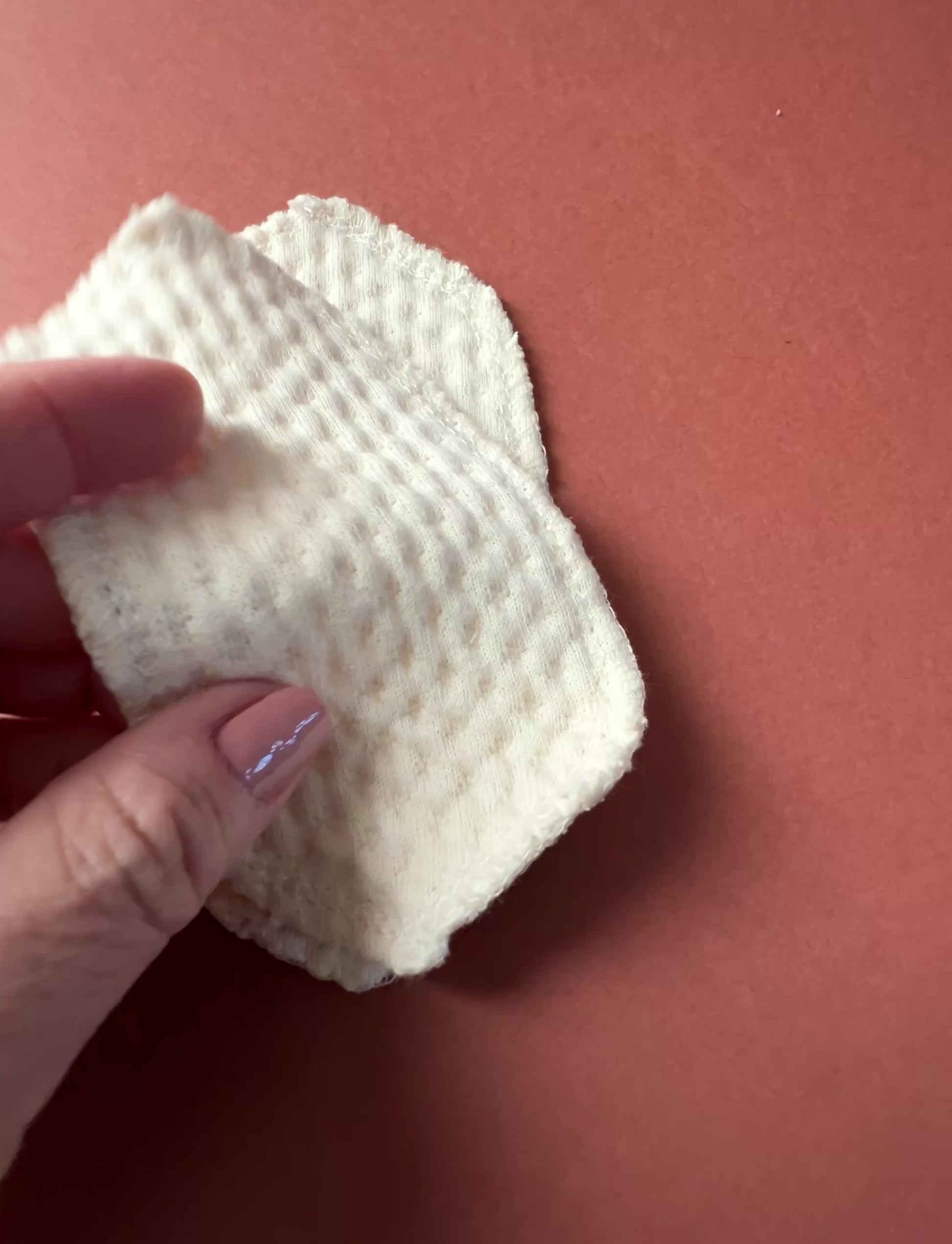Organic cotton interlabial pad shown in close-up, featuring soft exposed organic cotton and washable reusable design for everyday period care