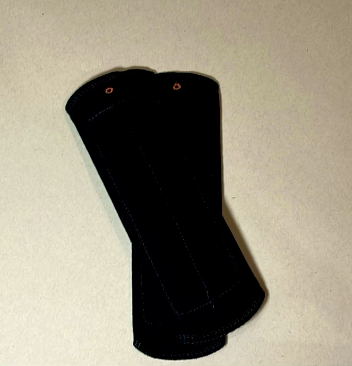 Black reusable day pad shown in close-up, featuring soft cotton fabric, snap closure, and washable design for everyday period care