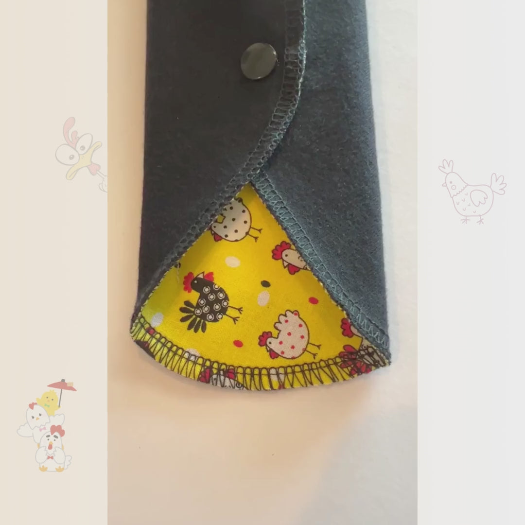 Video showing the Yellow Chicken Reusable Period Pad from Hume’s Period Care with bright yellow chicken print, black cotton absorbent side, snap wings, and washable cloth pad design.
