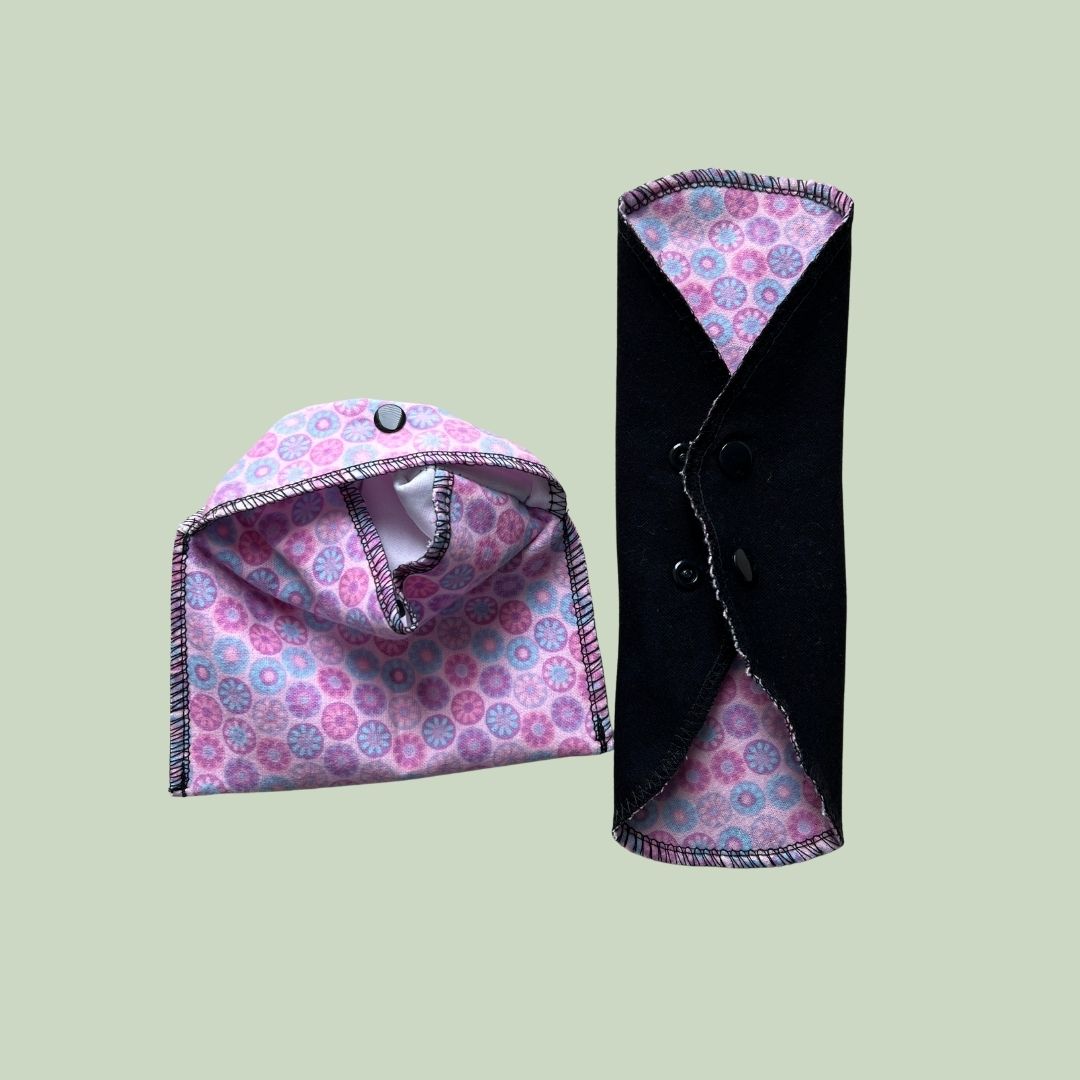 Pink cloth pad wrapper with a folded reusable period pad ready for school or travel.