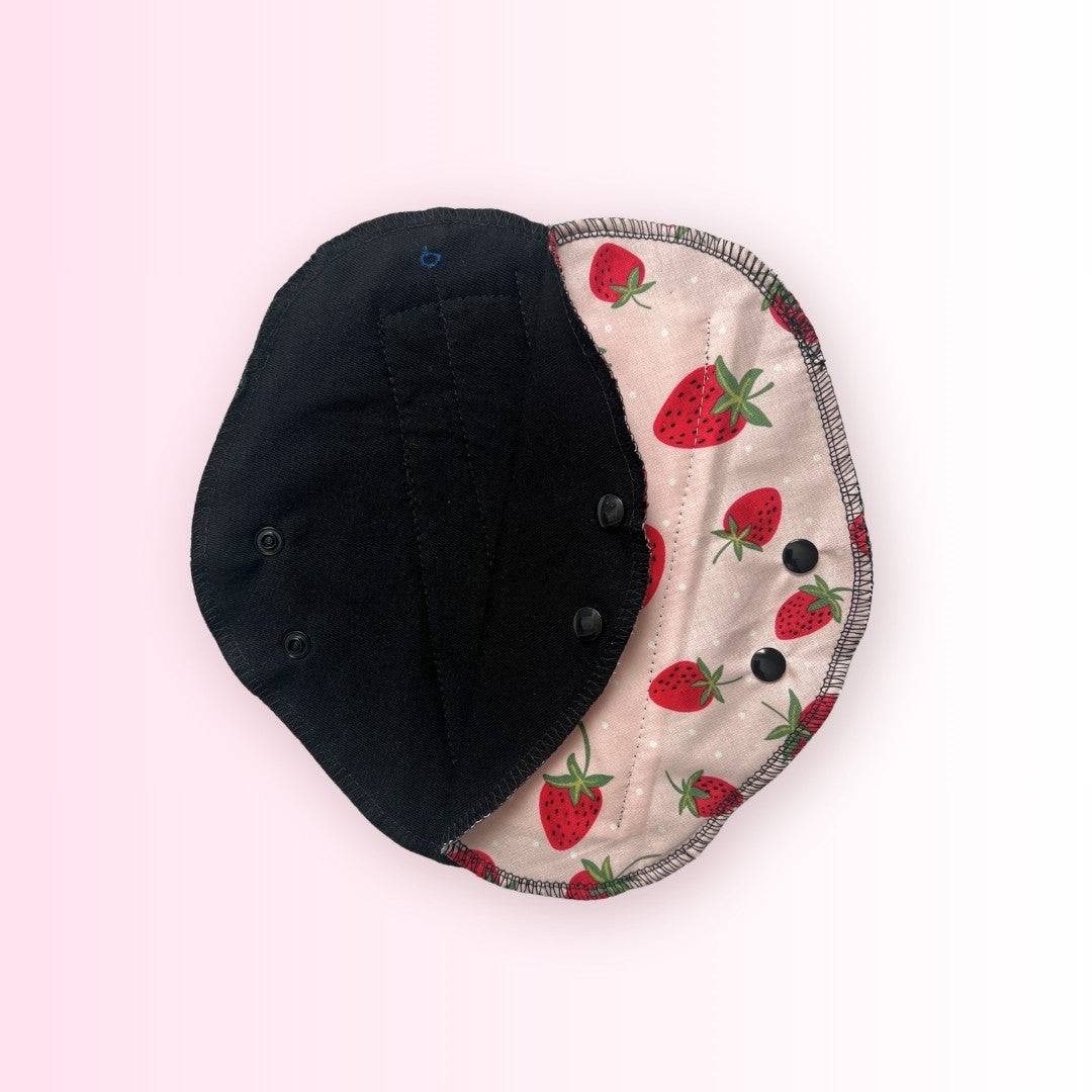 Strawberry reusable period pad showing the absorbent inner side.