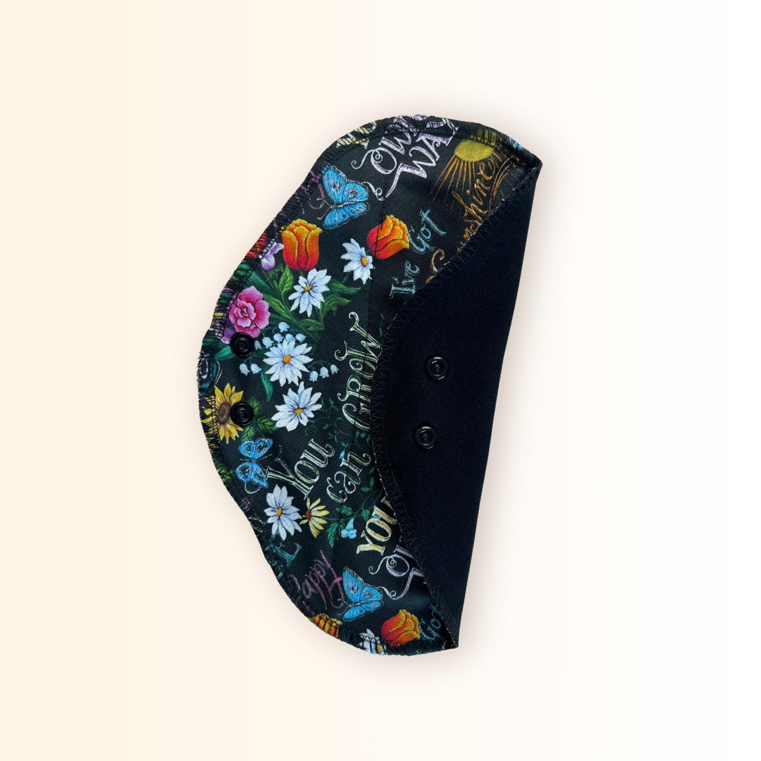 Black sunflower print washable period pads with snap wings.