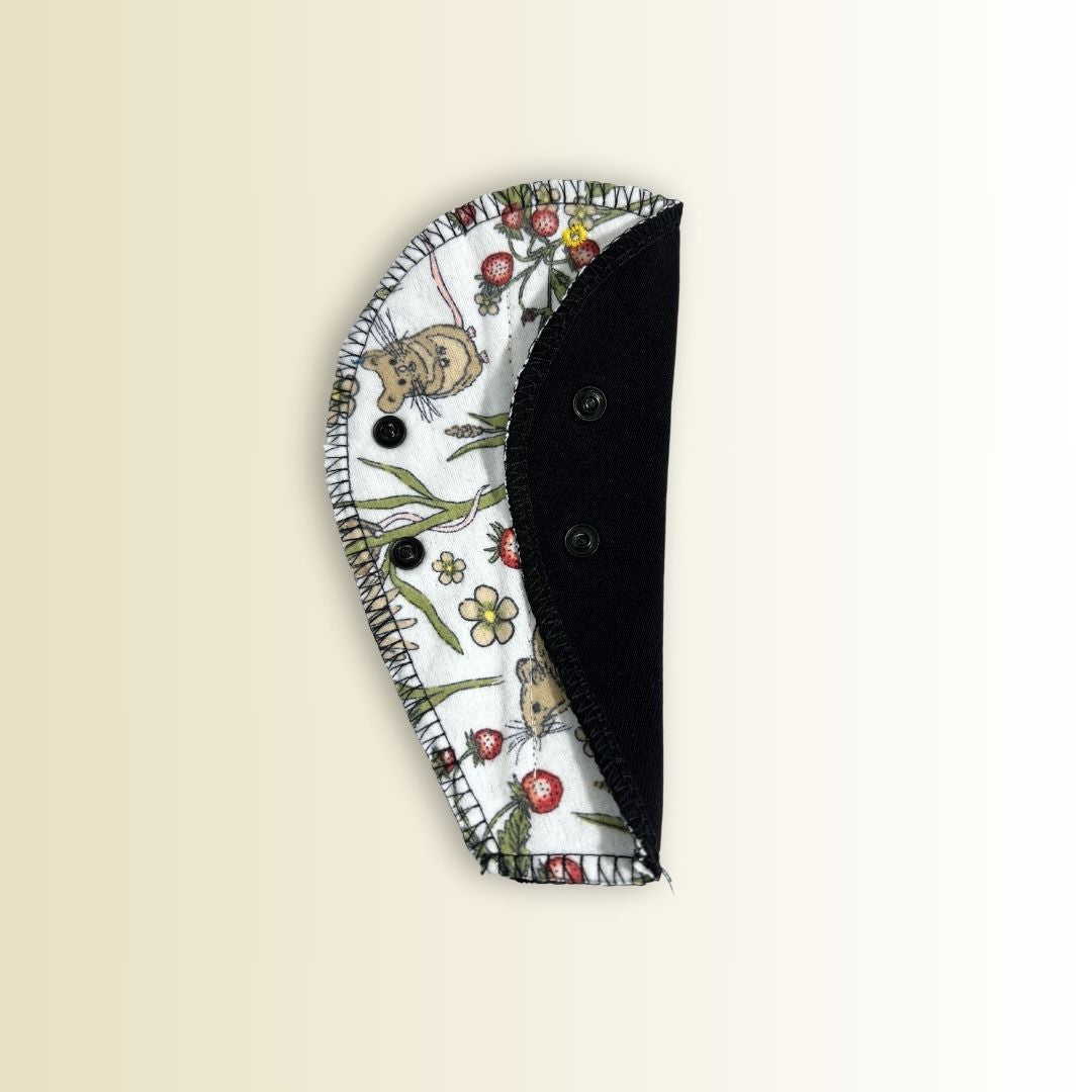 Thong pad showing black absorbent side with snap closure. Organic cotton core with eco-friendly leakproof backing.