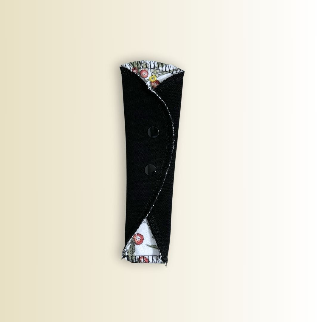 Folded reusable thong liner with black snap buttons. Compact and discreet for everyday freshness.