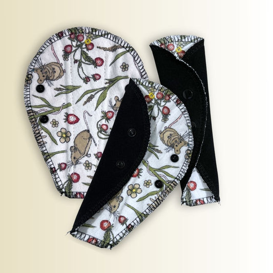 Set of reusable thong panty liners in whimsical mouse print, featuring breathable fabric and black absorbent backing.
